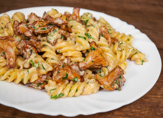 fusilli pasta with mushroom and cream sauce on a wooden background