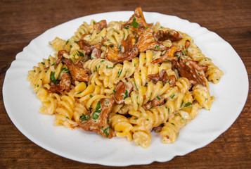 fusilli pasta with mushroom and cream sauce on a wooden background