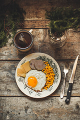 fried egg, cheese, sausage, corn and other products on a wooden surface