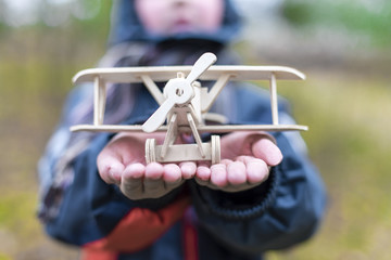 a wooden plane in the hands of a child