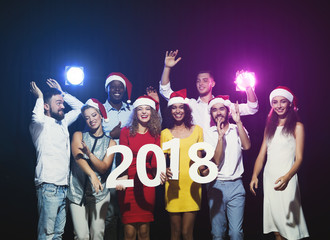 Young multiethnic people with wooden numbers 2018