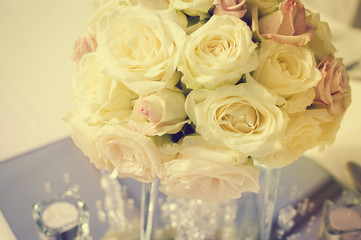 Bright close up of natural beautiful roses in light color style on blur bokeh textured background. Special event festive detail, sweet purity abstraction