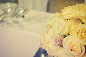 Bright close up of natural beautiful roses in light color style on blur bokeh textured background. Special event festive detail, sweet purity abstraction