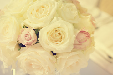 Bright close up of natural beautiful roses in light color style on blur bokeh textured background. Special event festive detail, sweet purity abstraction