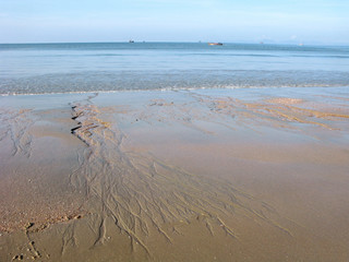 Coast after large ebb on the sea. Sandy patterns of flowing water. Tropical climate. Islands and...