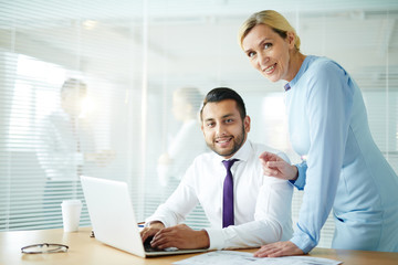 Happy and successful colleagues preparing presentation for conference