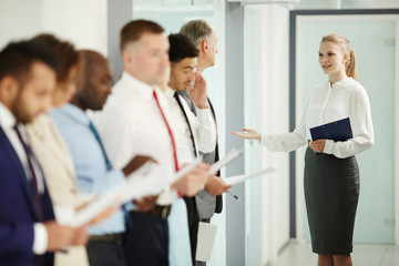 Fototapeta premium Young secretary inviting next candidate for interview to boardroom