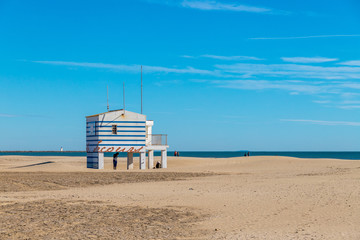 un poste de secours sur la plage, avec des rayures bleues, sur pilotis, aux Gruissan