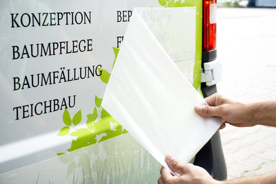 Abziehen von &Uuml;bertragungspapier bei Fahrzeugbeschriftung