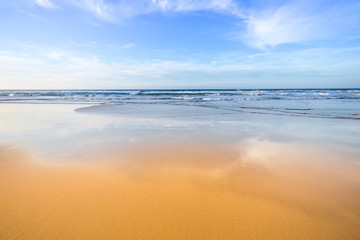 Amazing beach sunset with endless horizon and idillic yellow, smooth sand