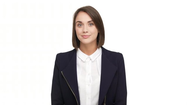 portrait of caucasian short-haired woman with beautiful blue eyes wearing business suit posing at camera with kind look smiling over white background in studio. Concept of emotions