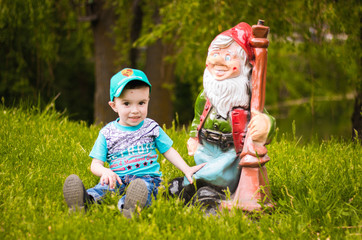 boy sitting with dwarf on green grass