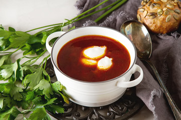 Russian traditional food borscht with sour cream. Soup from beets, cabbage, carrots, tomato. Light background.