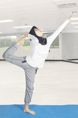 Muslim woman doing yoga at gym