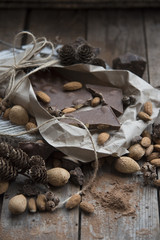 chocolate, nuts, cones, cocoa on a wooden background
