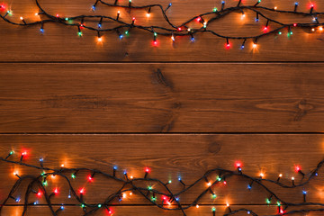 Christmas lights border on wood background