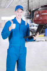Mechanic with laptop and thumb up