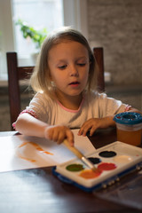 A little girl  drawing with watercolors