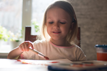 A little girl  drawing with watercolors