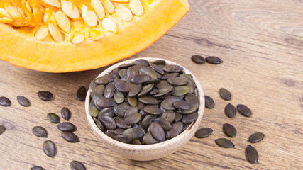 Pumpkin seeds on a wooden background.