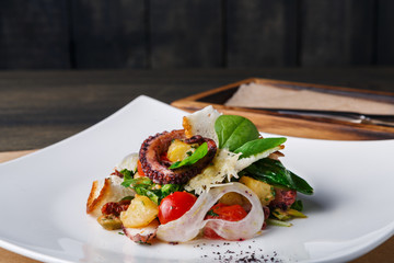 Salad with octopus and vegetables top view