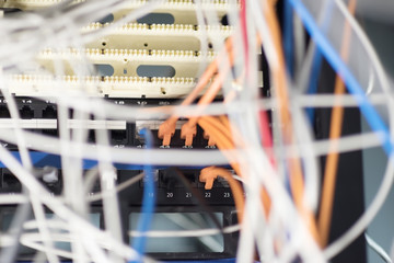 server room. A lot of different colors internet wires have a connection to computer servers. Cabinets with computer equipment are located in the data center