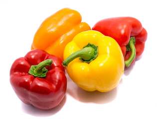 Group of peppers, two red, one yellow and one orange isolated on white background.