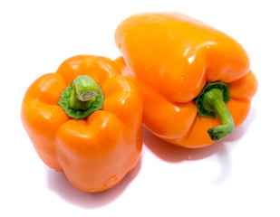Group of orange peppers, one pepper on back, isolated on white background.