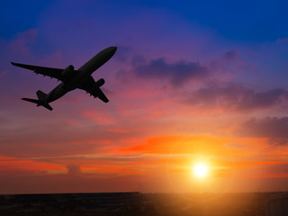 Fototapeta na wymiar Silhouette airplane above the sunset sky