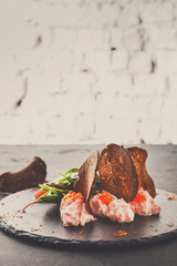 Gourmet seafood snack on black plate copy space