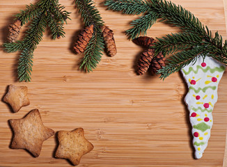 Composition of New Year's biscuits and fir branches on a wooden background, Christmas background. Christmas cookies.