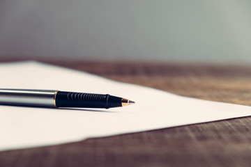 pen and paper on wood background with filter effect retro vintage style