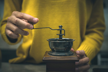 Woman working with coffee grinder. Cafe restaurant service, food and drink industry concept.