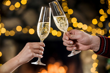 Celebreating christmas and new year. Couple keeps and toasts champagne glasses