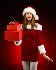 Beautiful woman in Santa Claus clothes holding gift boxes