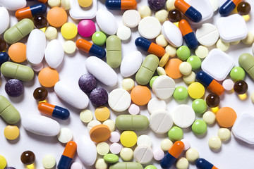 texture of multicolored pills and capsules on the white background