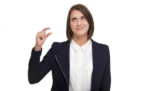 portrait of skeptically smiling woman 30s wearing in casual doing size gesture with fingers expressing dislike while standing isolated over white background. Concept of emotions