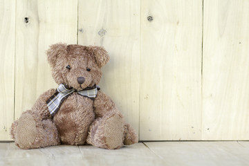 Teddy bear sitting on the wooden floor.