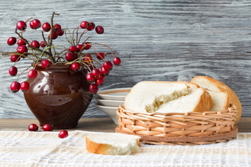 Hawthorn in a ceramic pot and bread in a wattled plate, rural style.