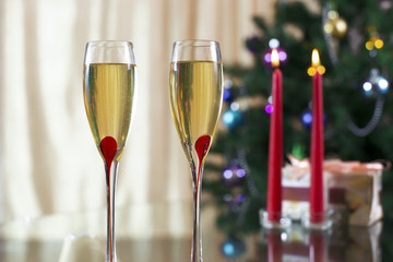 wineglass with champagne, Christmas spruce, gifts and candles