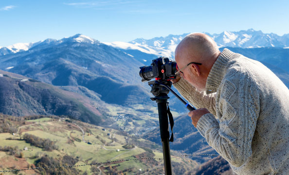 photographer with digital camera on top of the mountain