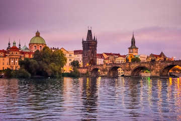 Fototapeta na wymiar Manes bridge in Prague, Czech Republic at sunset. Ducks and swans on the river