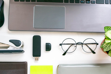 Flat lay, top view office table desk frame. feminine desk workspace with laptop, diary, succulent, glasses, watch on white background.