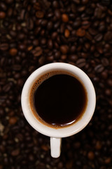 Cup of coffee on coffee beans