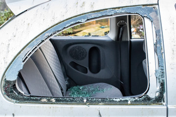 Broken car window with smashed glass all over the rear seat