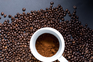 Mug of coffee and grains all around. View from top to flat lying.