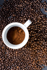 Mug of coffee and grains all around. View from top to flat lying.