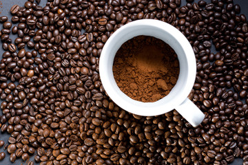 Mug of coffee and grains all around. View from top to flat lying.