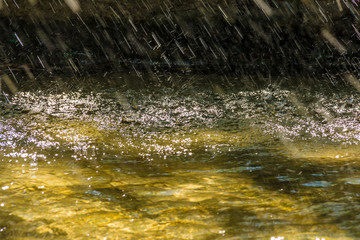 Abstract photo of water surface with ripple and many falling drops