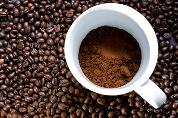 Mug of coffee and grains all around. View from top to flat lying.